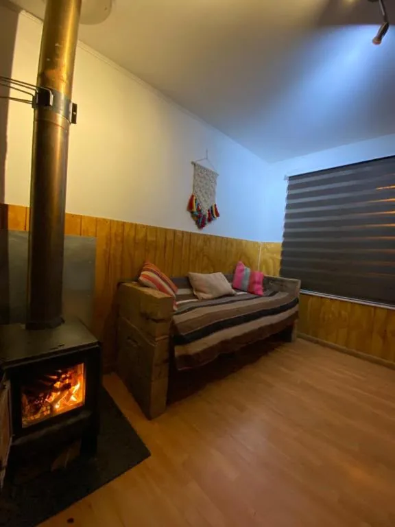 Sala de estar y estufa a leña de la Cabaña Familiar 1